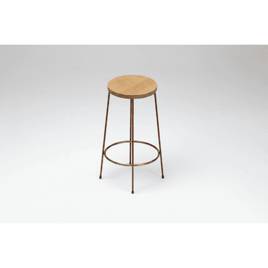 A minimalist bar stool featuring a round, natural oak wood seat and a slender four-legged metal base. The legs are a dark reddish-brown hue, tapering slightly towards the floor, and are reinforced with a circular brass-toned metal footrest. — 3D model (AI enhanced source)