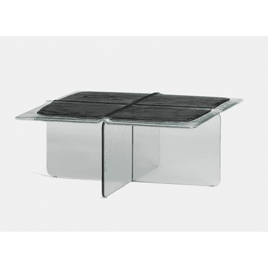 A contemporary coffee table constructed primarily from thick, clear glass. The design features a square tabletop with gently rounded edges and a central recessed area containing four distinct, textured black panels, possibly a form of faux leather or polymer. The base is formed by two intersecting glass panels, creating a stable cross-shaped support structure. The overall aesthetic is minimalist and sculptural, highlighting the material properties of glass and the contrast with the dark, textured surface. — 3D model (AI enhanced source)