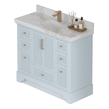 A light blue bathroom vanity featuring a white marble countertop with an integrated rectangular sink and an attached backsplash. The cabinet base has ribbed detailing on its drawer and door fronts, accented with gold-finished hardware (knobs and pulls). A gold single-handle faucet is mounted on the countertop. Decorative bathroom accessories are placed on a wooden tray to the right of the sink. — 3D model (AI enhanced source)