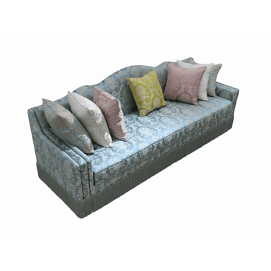 An ornate traditional three-seater sofa, upholstered in a light blue patterned brocade fabric. It features a gently curved backrest and rolled arms, with a decorative fringe trim along the bottom edge. Several throw pillows in varying complementary colors and patterns are arranged on the seat. — 3D model (AI enhanced source)