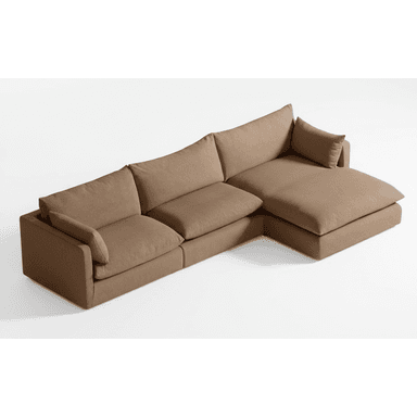 A large, modular sectional sofa upholstered in a neutral taupe-brown fabric. It features a three-seat configuration with a right-hand facing chaise lounge, offering ample seating. The design is characterized by its low-profile frame, deep, plush seat and back cushions, and wide, flat armrests on the left end. The overall aesthetic is contemporary and emphasizes comfort. — 3D model (AI enhanced source)