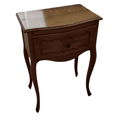 A wooden nightstand with a single drawer and curved legs. The drawer front features an ornate, molded design. The top surface appears to be lighter wood and shows some signs of wear. The body and legs are a darker, polished wood. — 3D model (AI enhanced source)
