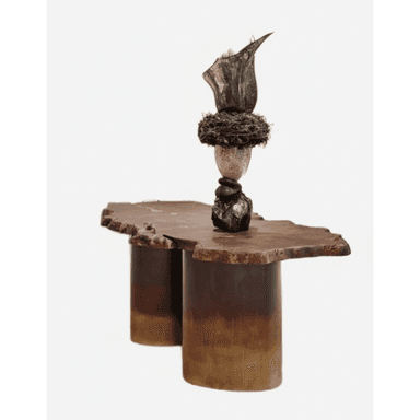 A coffee table with a live-edge, irregular-shaped wooden top supported by two cylindrical, gradient-colored bases. The table top features a natural, organic edge. A sculptural element made of stacked stones and natural materials is placed on one side of the table. — 3D model (AI enhanced source)