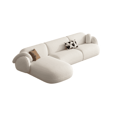 A sectional sofa with a cream-colored fabric upholstery. It features rounded arms and a low profile. The sofa is configured in an L-shape, with one section appearing to be a chaise lounge. Two decorative throw pillows are placed on the sofa: one with a brown textured pattern and the other with a black and white abstract design. — 3D model (AI enhanced source)