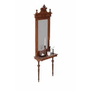 A tall, ornate wooden console table integrated with an upright mirror. The piece features elaborate carvings, finials, and turned legs, characteristic of Victorian-era design. The dark wood has a visible grain and appears to be solid hardwood. The mirror is framed by the carved wood, and a small console surface is positioned below it, supported by two turned front legs. The surface shows some signs of age and wear. — 3D model (AI enhanced source)