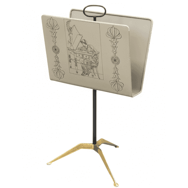 A freestanding magazine rack featuring a light-colored enameled metal trough adorned with black Art Deco-style line art illustrations. It is supported by a slender dark metal central pole and a distinctive three-legged brass base. A dark metal loop handle is integrated at the top for portability. — 3D model (AI enhanced source)