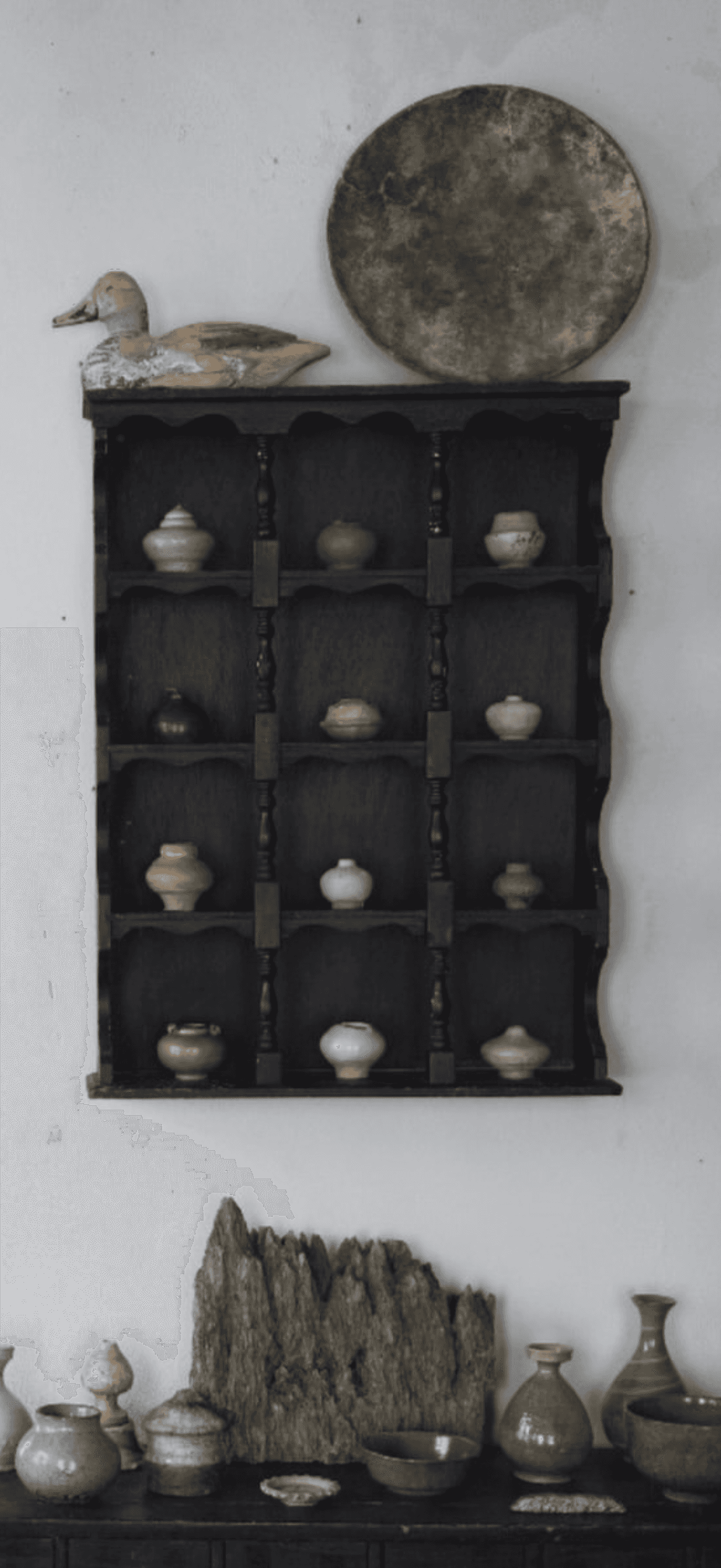 A black, wall-mounted display shelf featuring a tiered structure with scalloped side panels and turn… — 3D model