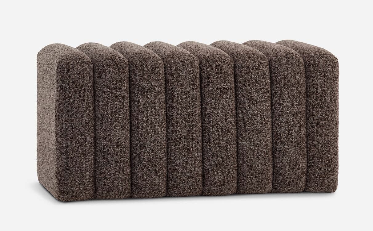 A rectangular ottoman upholstered in a textured brown fabric. It features a series of vertical, rounded, channel-tufted panels across its top surface, creating a ribbed effect. The sides are solid and also upholstered. — 3D model