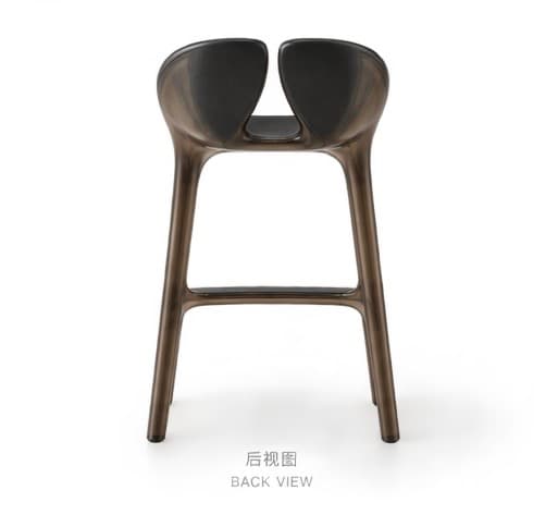 A contemporary bar stool featuring a sculptural form, made from a dark, potentially translucent, molded material. It has a distinctive split backrest and an integrated footrest, with a continuous, flowing design from the seat to the legs. — 3D model