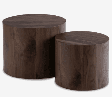 A set of two cylindrical side tables. The larger table is positioned to the left and slightly behind the smaller table. Both tables share a consistent dark brown wood grain finish. They have a solid, block-like appearance with rounded edges. — 3D model