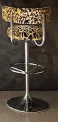 An adjustable swivel bar stool featuring a plush, curved seat and backrest upholstered in a distinctive leopard print fabric. The stool is supported by a polished chrome base with a circular footrest and a hydraulic lift mechanism for height adjustment. — 3D model