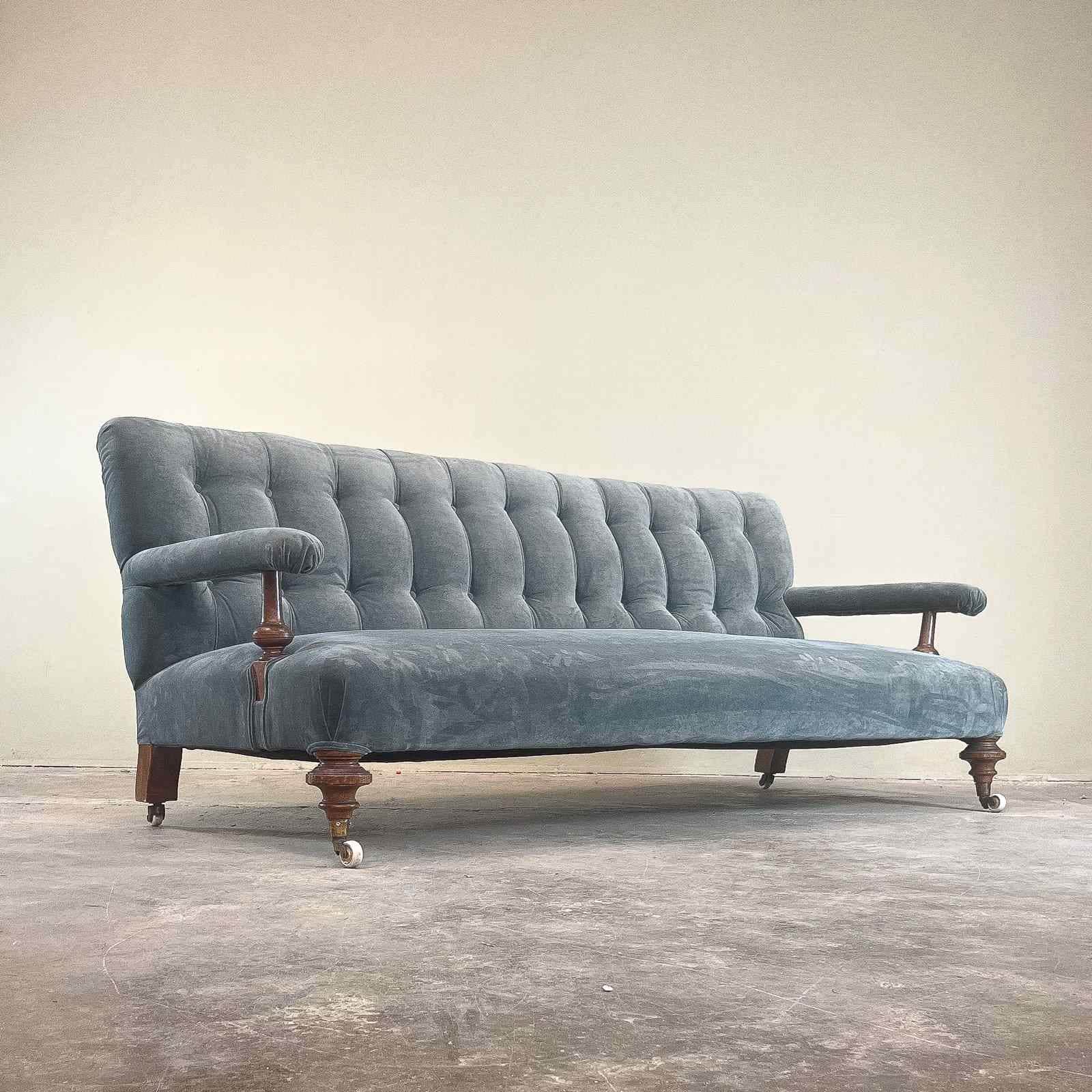A vintage-style sofa with a tufted backrest and seat. It features upholstered armrests supported by… — 3D model