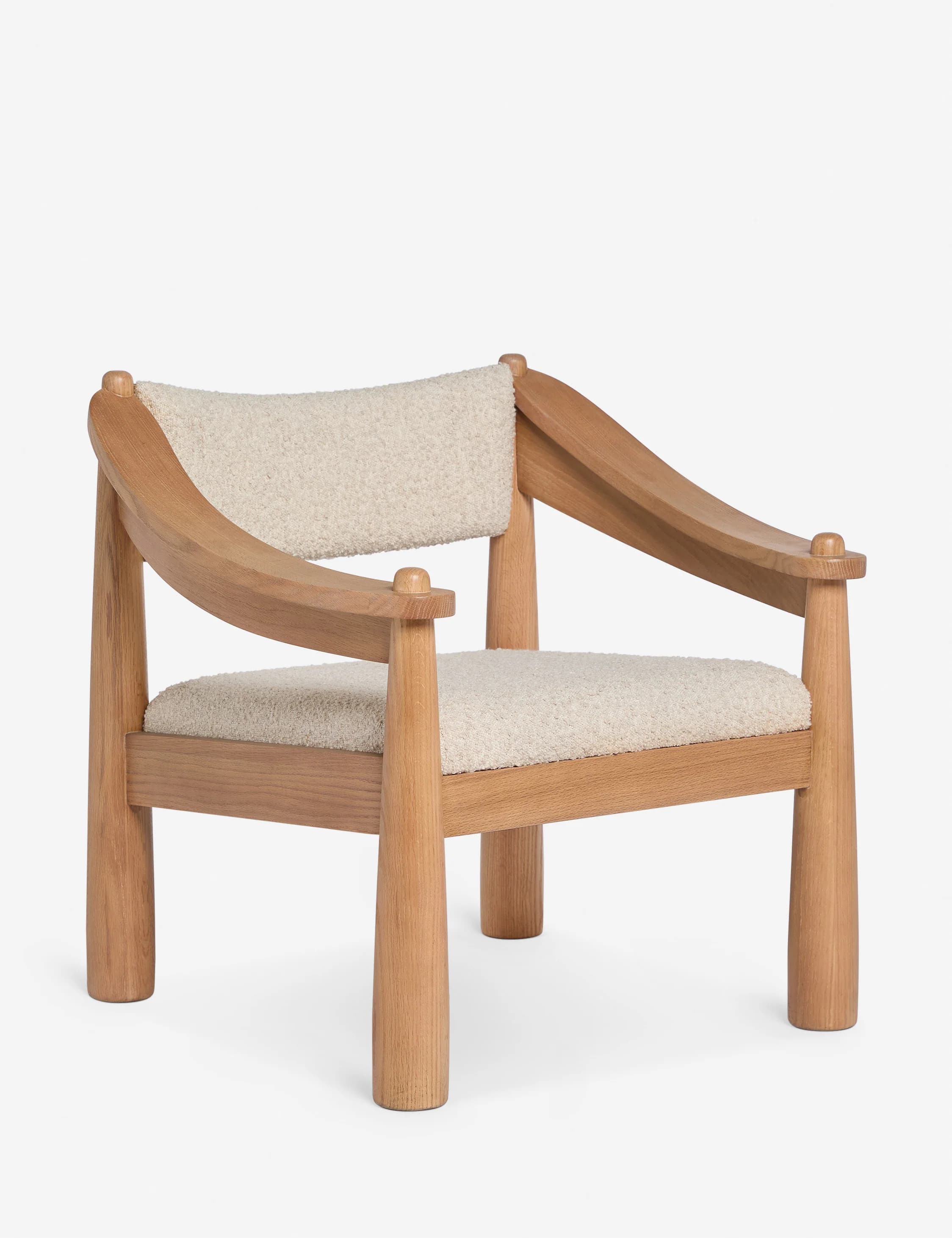 A modern armchair with a solid wood frame and upholstered seat and backrest. The frame features rounded, tapered legs and armrests, with curved supports for the back. The upholstery appears to be a textured boucle fabric. — 3D model