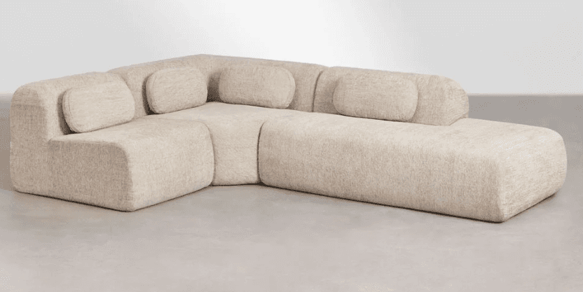 An L-shaped modular sectional sofa in a light beige, textured fabric, featuring soft, rounded edges… — 3D model