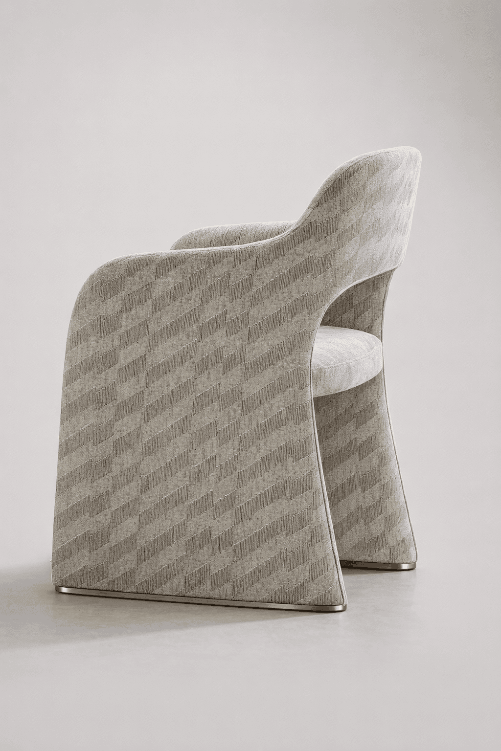 An armchair with a distinctive, sculptural design. The piece features a fully upholstered body with a textured fabric. The armrests and backrest curve gracefully, merging into the flared base. A thin, metallic trim runs along the bottom edge of the base. — 3D model