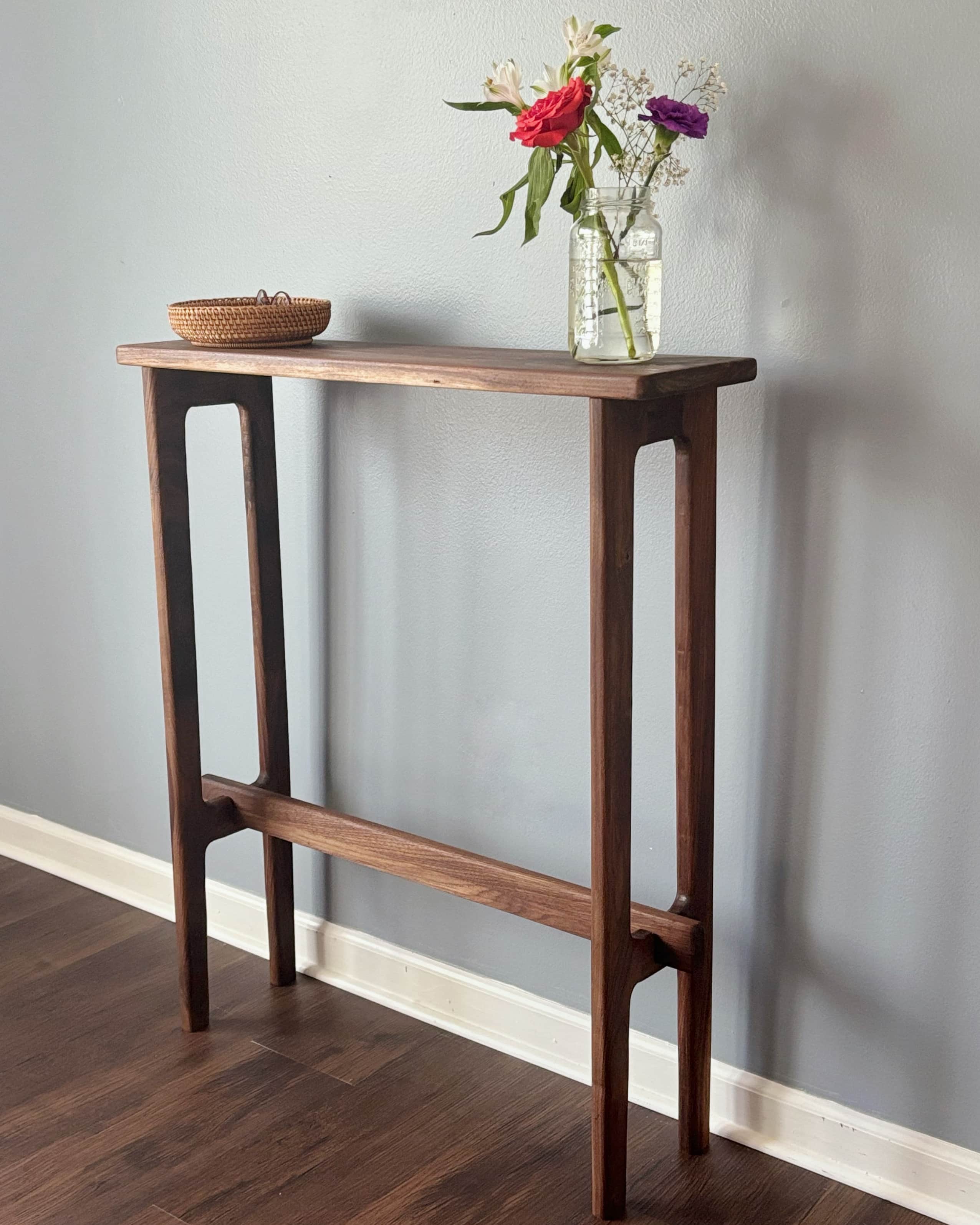 A minimalist, slimline console table crafted from dark walnut wood, featuring a rectangular top and… — free BLEND 3D model