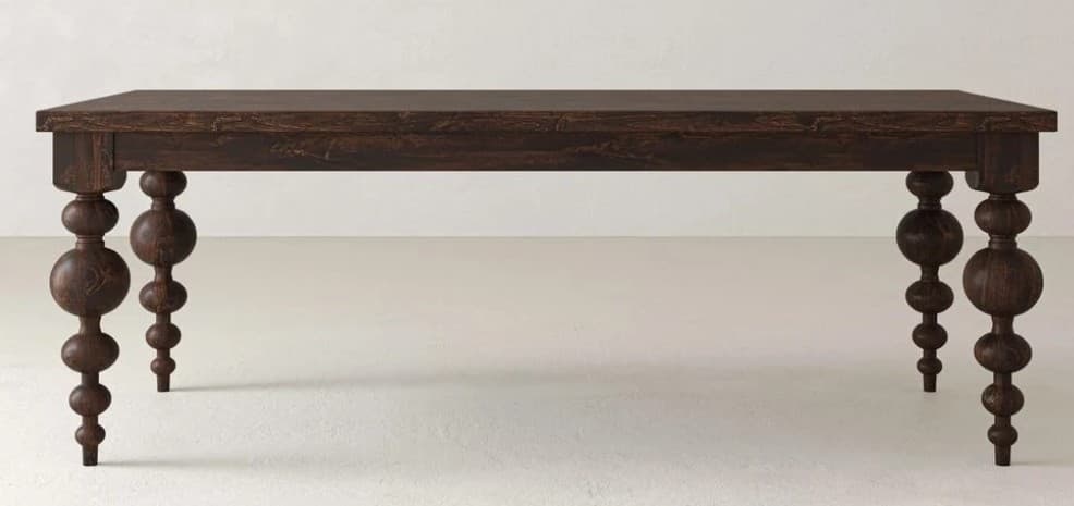A rectangular dining table crafted from dark-stained wood, featuring a thick tabletop and a deep apron. The most distinctive characteristic is its four bobbin-turned legs, each composed of a series of spherical and ovoid elements stacked vertically, providing a visually interesting and robust base. The wood has a visible grain texture, contributing to its rustic or traditional aesthetic. — 3D model