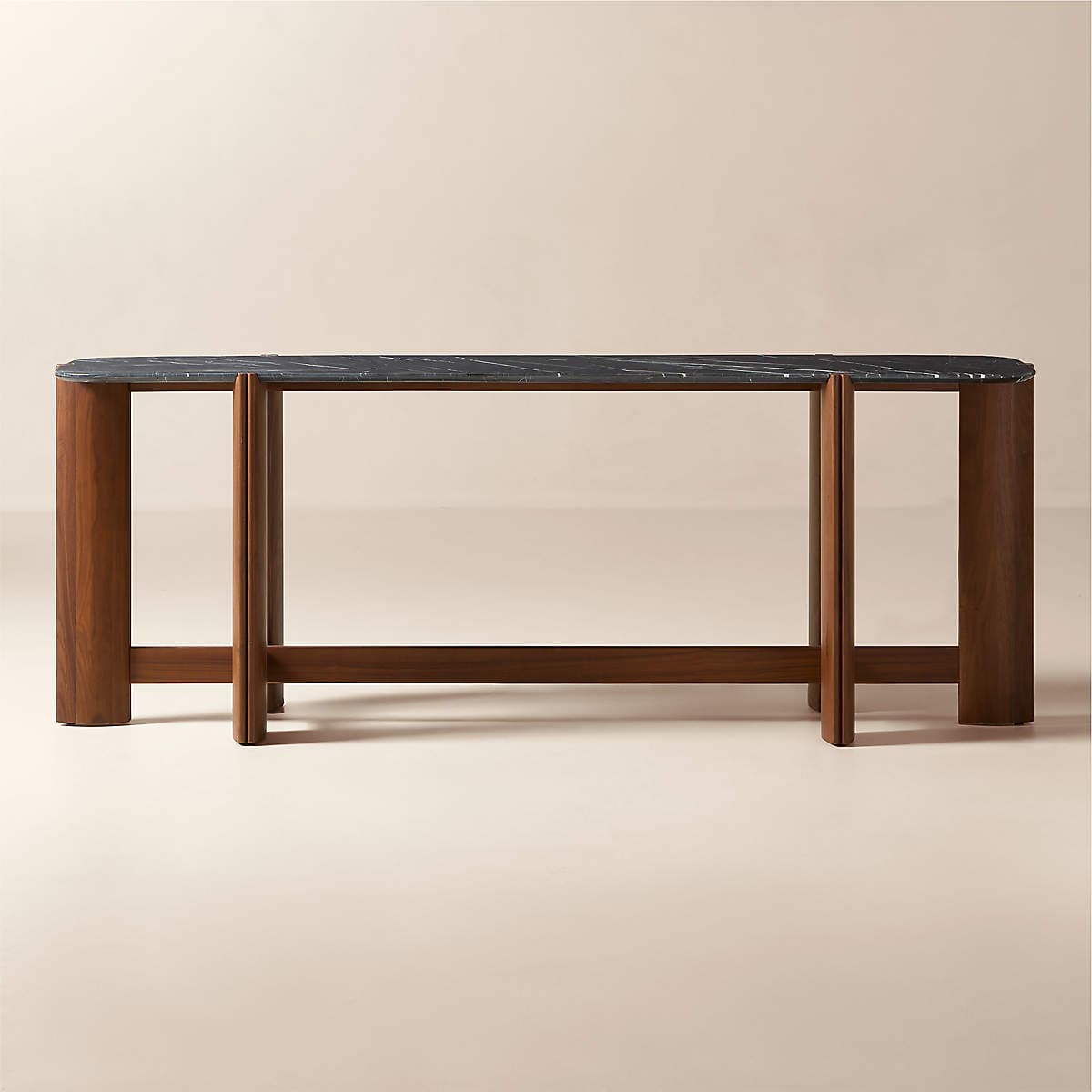 A modern console table featuring a rounded rectangular black marble top and a distinctive walnut wood base with splayed, geometric legs. — 3D model