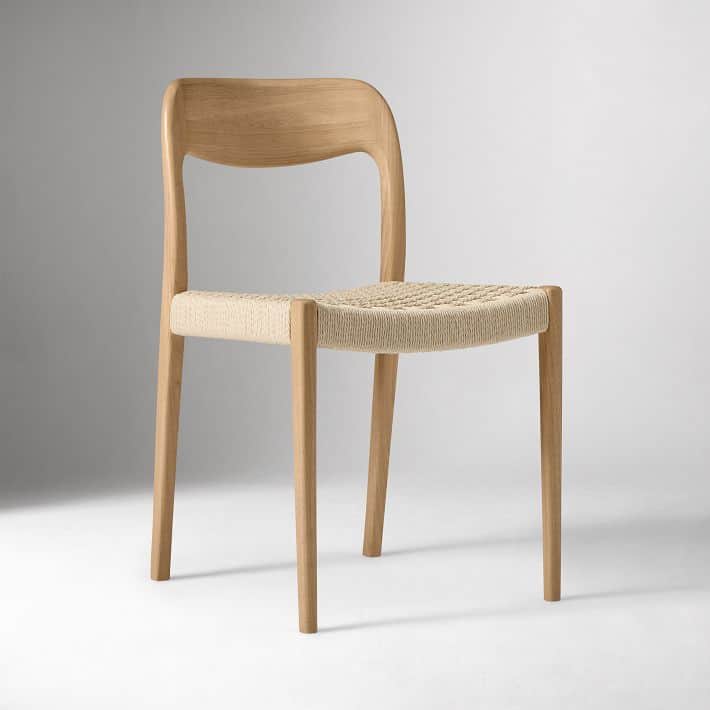 A light wood chair featuring a curved backrest and a woven seat. The chair stands on four straight,… — 3D model