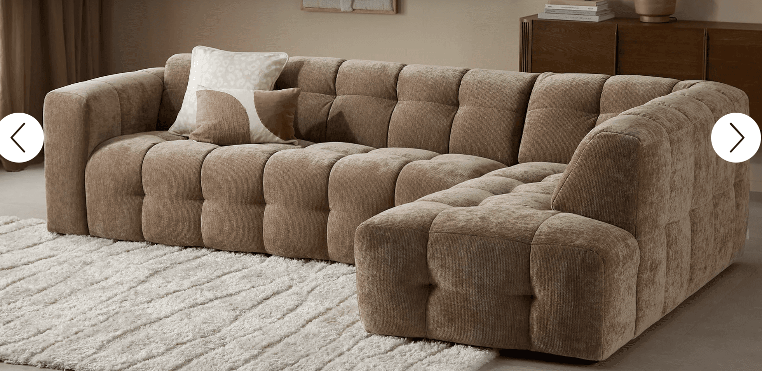 An L-shaped modular sectional sofa featuring extensive deep button tufting across all surfaces, including the low-profile arms and backrest. It is upholstered in a textured taupe fabric, presenting a modern, blocky silhouette. — 3D model