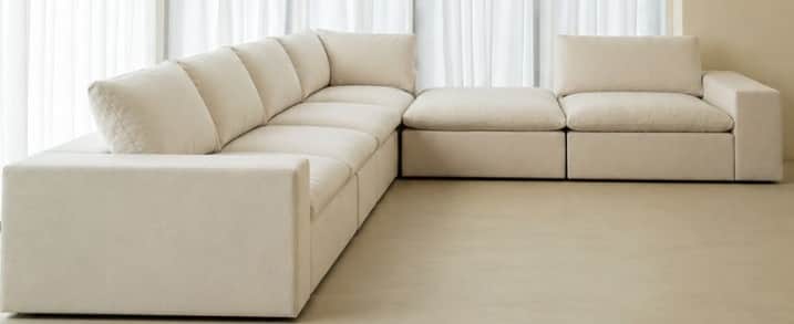An expansive, L-shaped contemporary modular sectional sofa upholstered in a light beige, textural fa… — 3D model