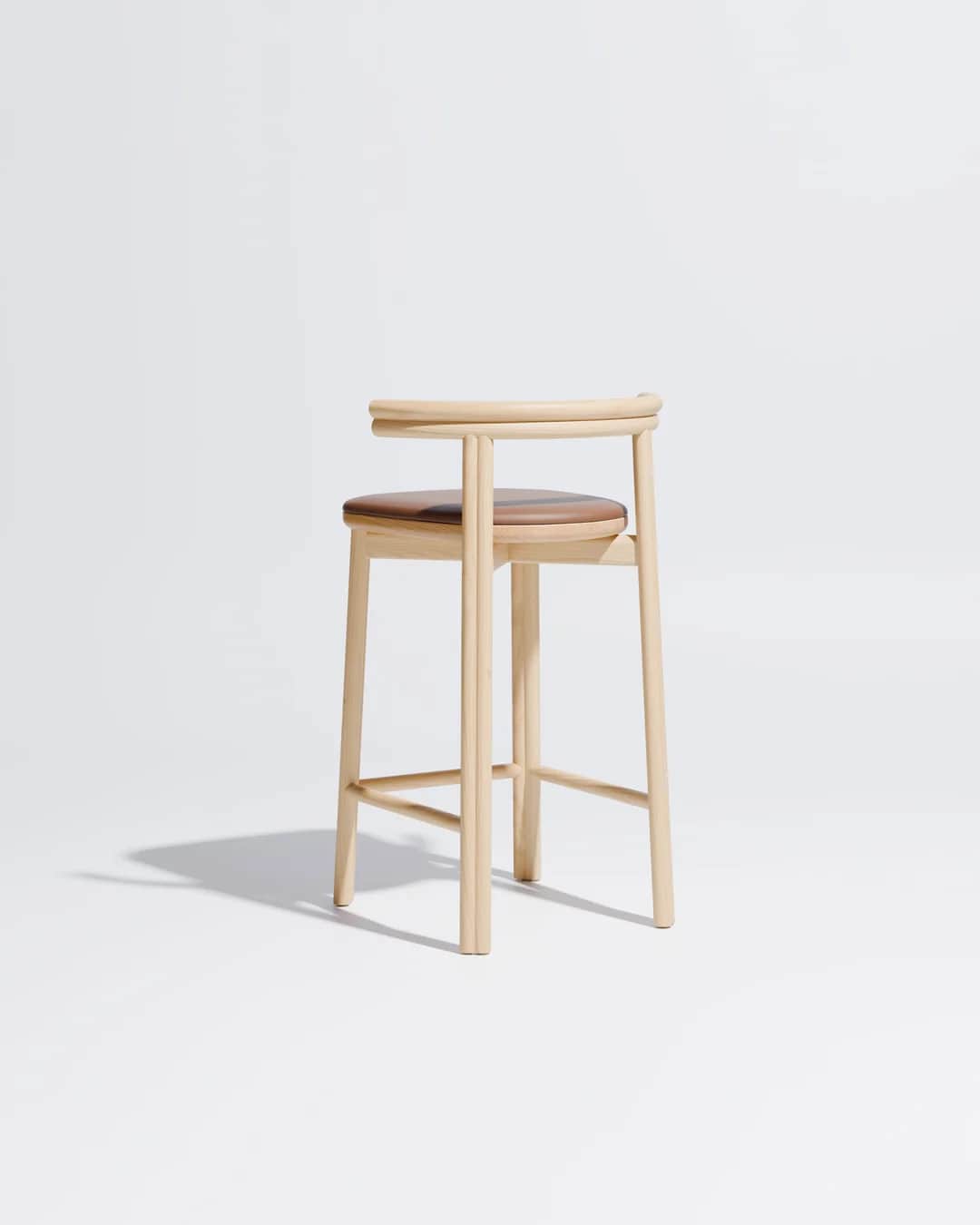 A minimalist bar stool constructed from light-toned oak wood featuring a subtly curved backrest that… — 3D model