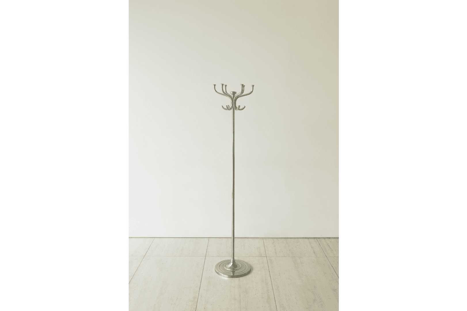 A floor-standing coat rack with a silver metallic finish, featuring a central pole, a round weighted… — 3D model