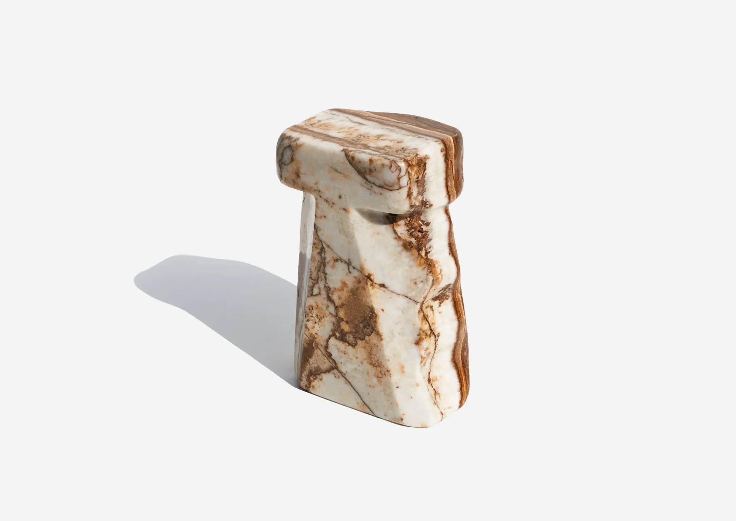 A small, monolithic piece of furniture carved from a single block of variegated marble, featuring a… — 3D model