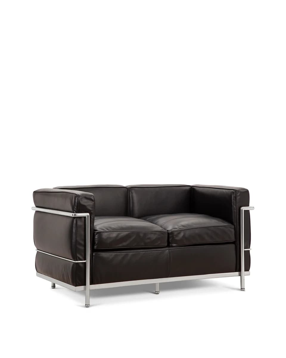 A two-seater sofa with a minimalist design. It features a polished chrome tubular steel frame that encases dark brown leather upholstery. The cushions are rectangular and appear to be tufted or divided into segments. The frame includes horizontal bars connecting the vertical legs at the bottom and upper sides, creating a distinct visual outline. — 3D model