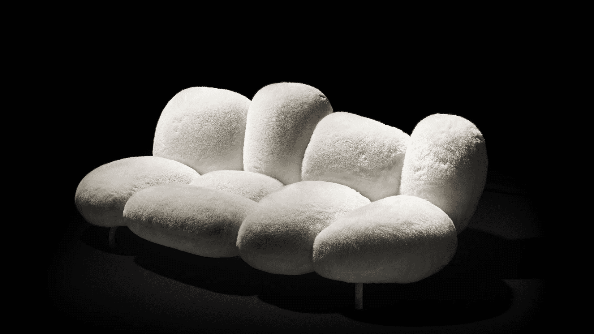 A contemporary three-seater sofa composed of multiple organically shaped, rounded cushions upholster… — 3D model