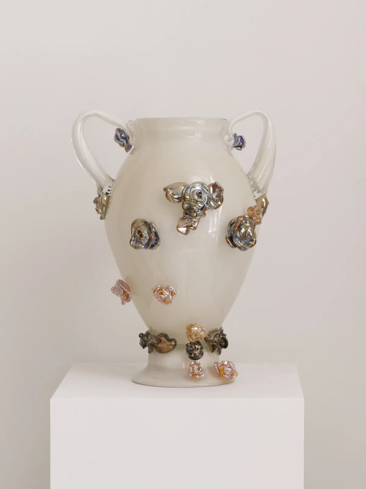 A decorative amphora-style vase made from opaline glass, featuring a milky white, semi-translucent body with two clear glass handles. The surface is embellished with numerous applied iridescent glass elements, scattered across the body and clustered near the base. These elements display a multi-color sheen. — 3D model