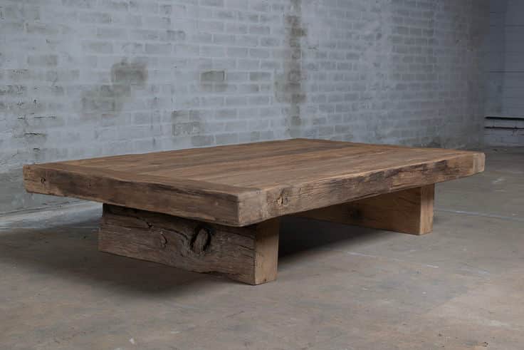 A rectangular, low-profile table constructed from reclaimed or distressed wood, featuring a thick, p… — 3D model