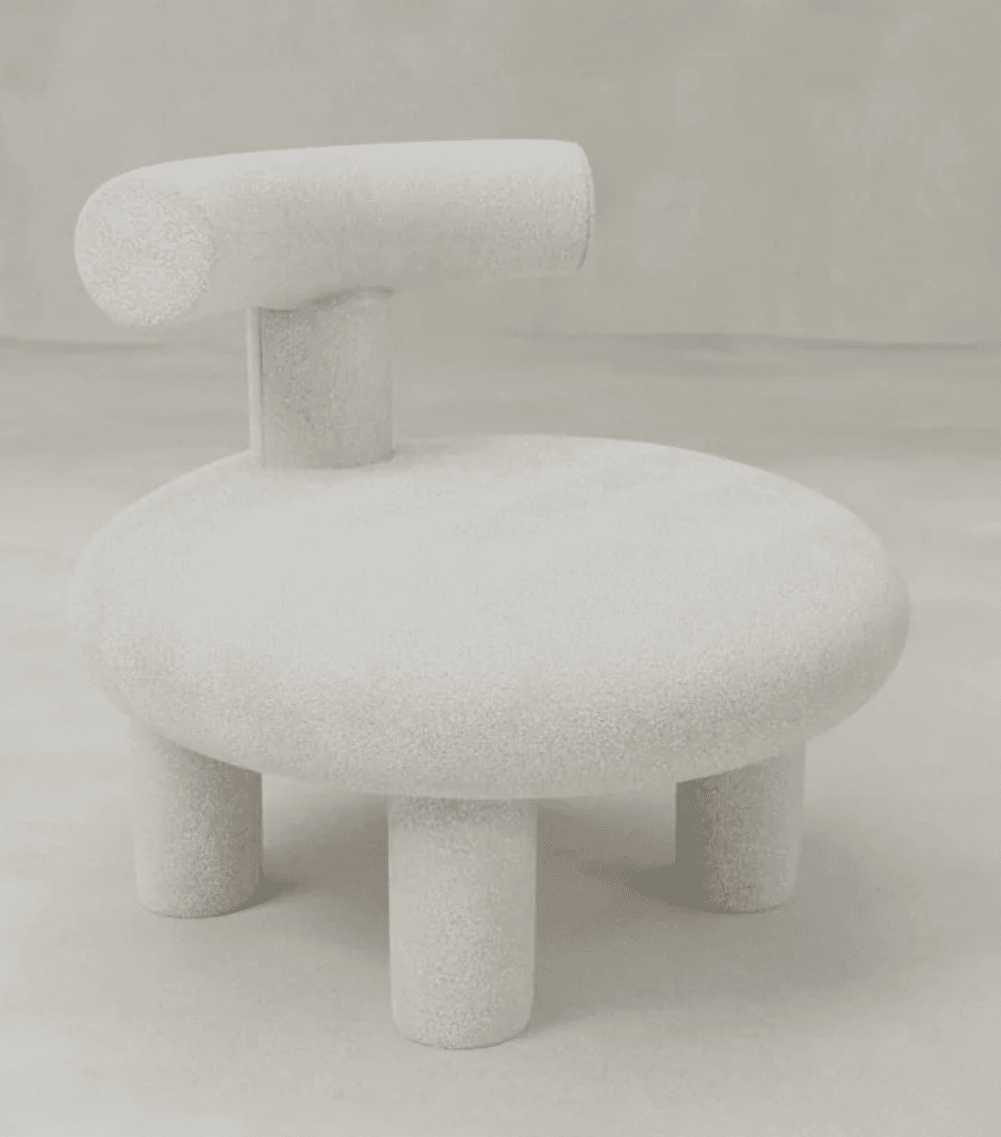 A sculptural accent chair with a unique silhouette. It features a circular, low-profile seat supported by four cylindrical legs. A prominent, horizontally oriented backrest, resembling a rounded bar, is attached to the center of the seat via a short, vertical support. The entire piece is covered in a textured, fluffy material. — 3D model