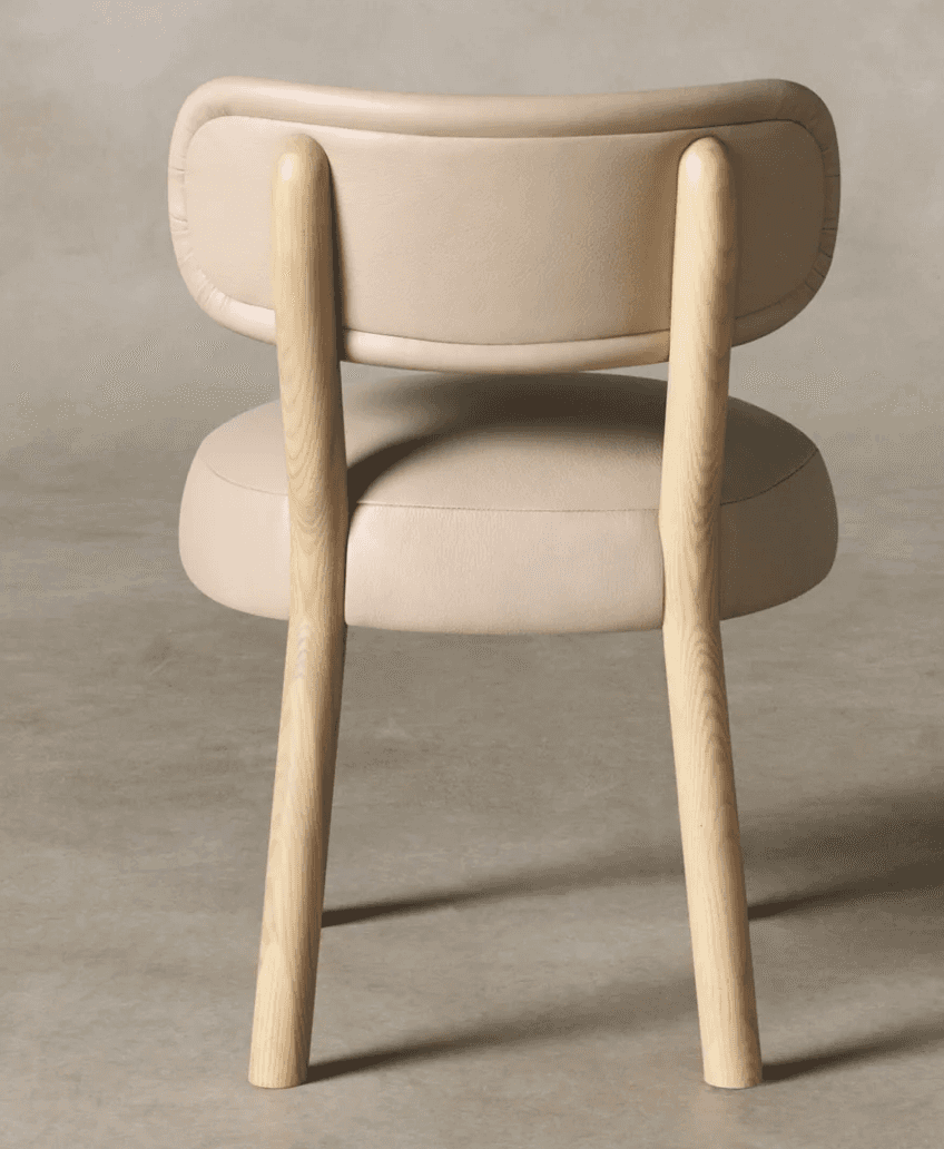 A contemporary armless dining chair featuring a light-toned natural wood frame and plush, rounded cu… — 3D model