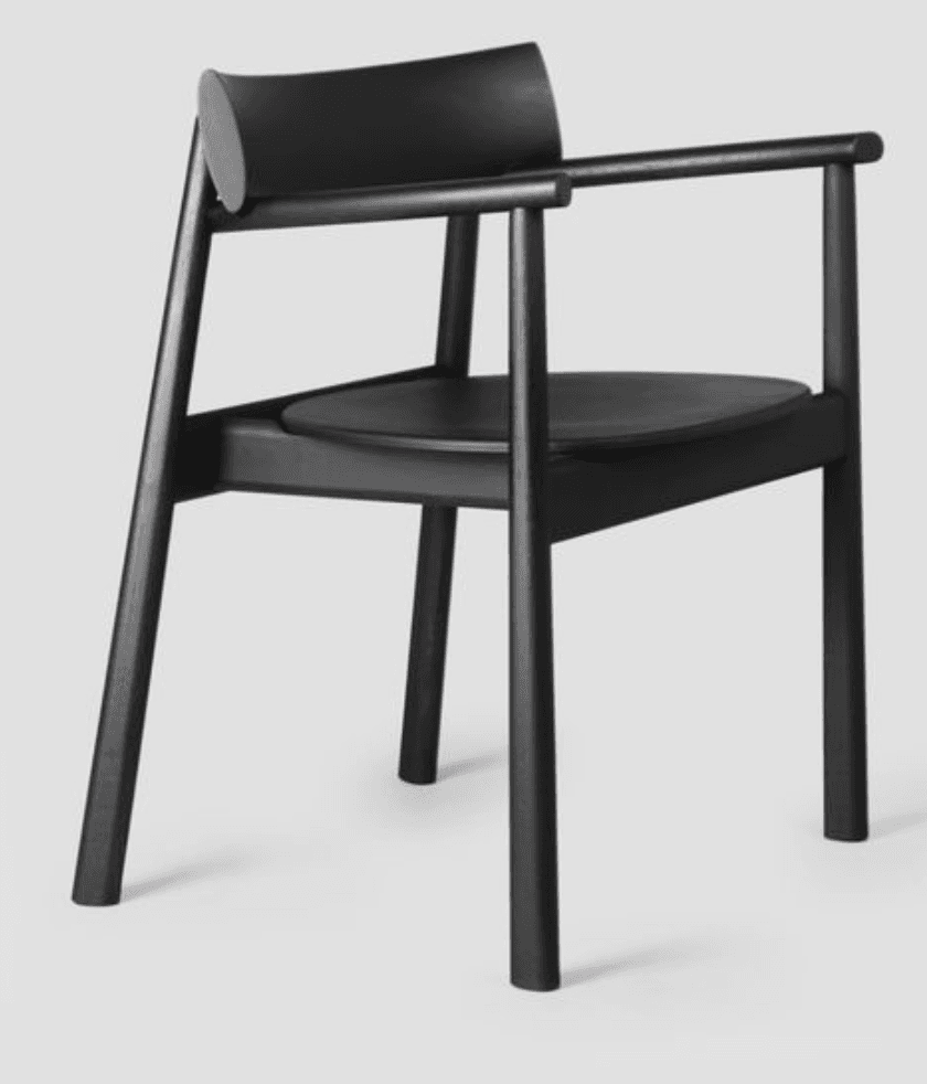 A minimalist armchair with a curved backrest and a circular seat. The armchair features a dark finish and a slender frame, including four legs, armrests, and a slightly elevated back support. The overall design is sleek and modern. — 3D model