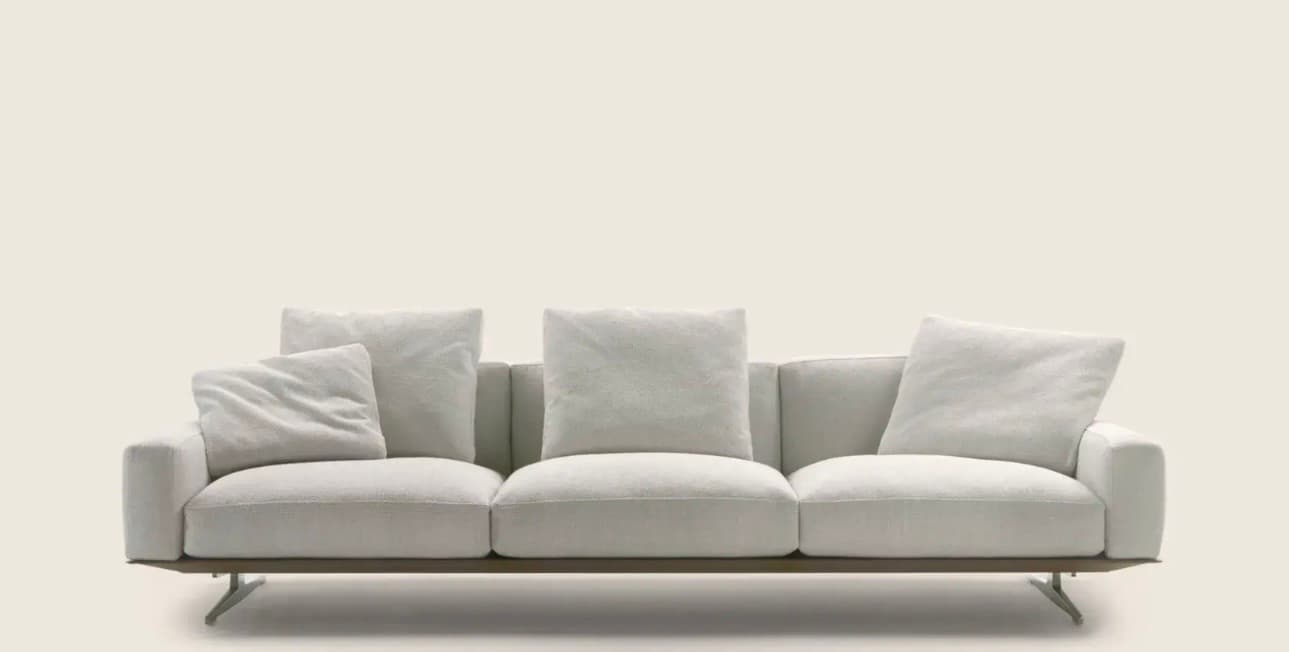 A contemporary three-seater sofa with plush cushions and a low profile. The sofa features a slim frame and metal legs, suggesting a modern design aesthetic. The upholstery appears to be a textured fabric. — 3D model
