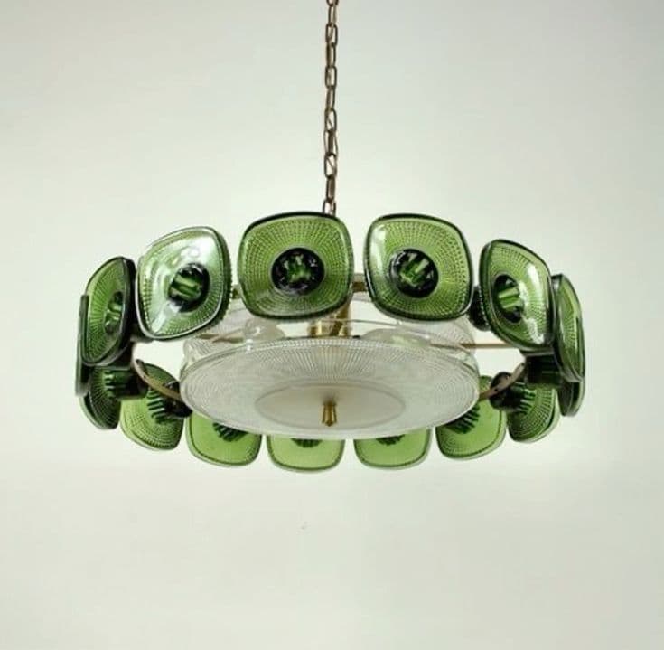 A circular chandelier featuring a brass-toned metal frame and numerous square-shaped, textured green glass elements arranged around its perimeter. It has several exposed light bulbs and is suspended by a metal chain. — 3D model