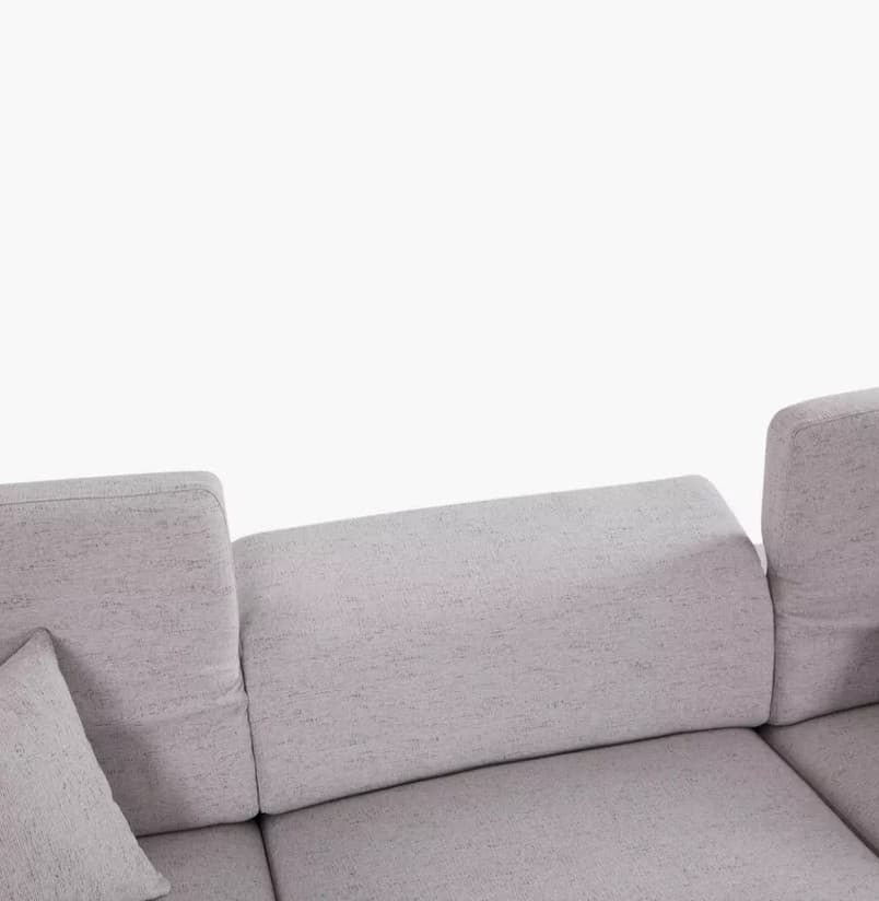 A section of a light gray, upholstered sofa is visible against a white background. The sofa features a modular design with distinct seat and backrest cushions. One armrest and part of a side cushion are also visible. The upholstery has a textured appearance with a subtle flecked pattern. — 3D model