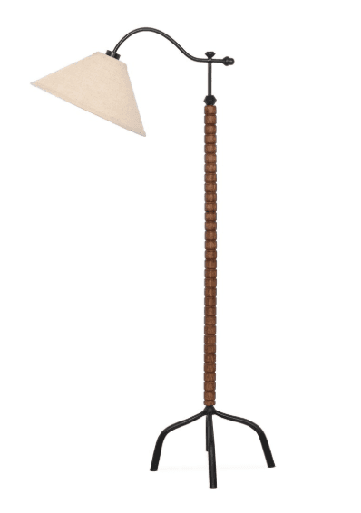 A contemporary floor lamp featuring a light-colored conical fabric shade suspended from a curved black metal arm. The lamp's vertical standard is composed of numerous stacked, dark brown wooden beads, culminating in a three-legged black metal tripod base. — 3D model