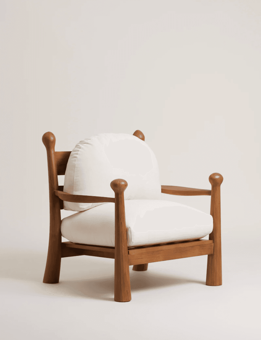 A contemporary lounge armchair featuring a robust, light-toned wooden frame and thick, off-white upholstered cushions for the seat and back. The frame is characterized by chunky, rounded legs that extend upwards to form the armrest supports, capped with spherical finials. The armrests themselves are flat and wide. The cushions are plush and provide deep seating comfort. — 3D model