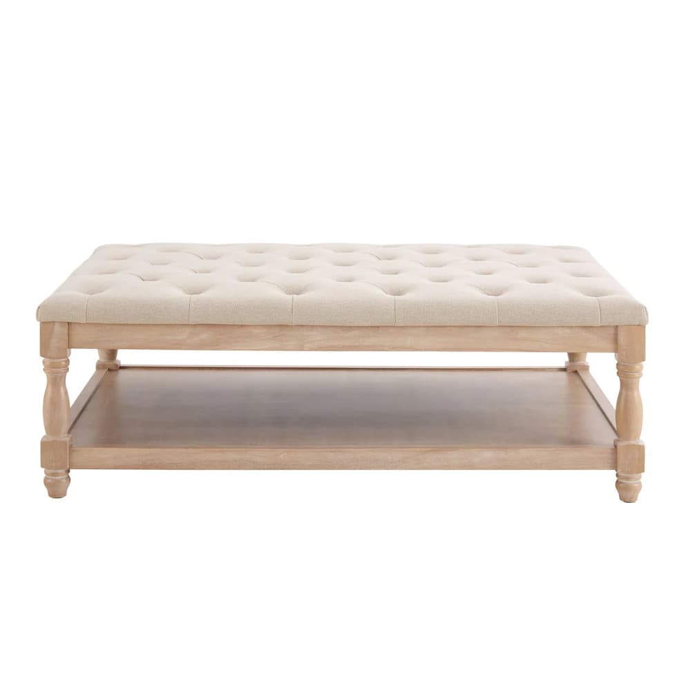 A rectangular coffee table with a tufted upholstered top and a lower wooden shelf. The table features turned legs and a light wood finish. — 3D model