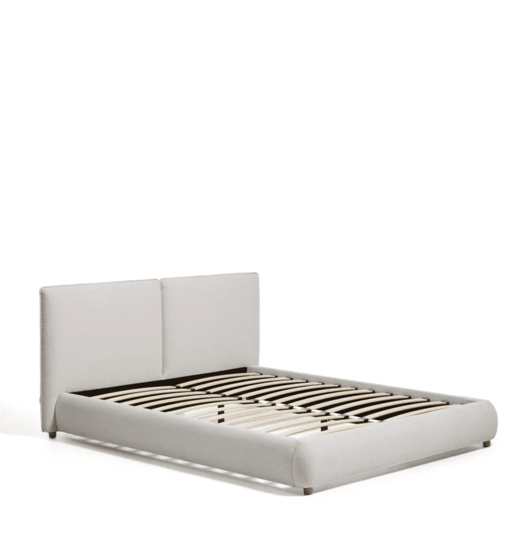 A light-colored, upholstered platform bed frame featuring a two-panel headboard and a low-profile base with a slatted mattress support system. The entire frame, including the headboard and footboard, is covered in a textured light fabric. It stands on small, unobtrusive wooden feet. — 3D model