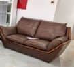 A modern two-seater sofa, upholstered in brown leather, featuring a distinct exposed wooden frame th… — 3D model