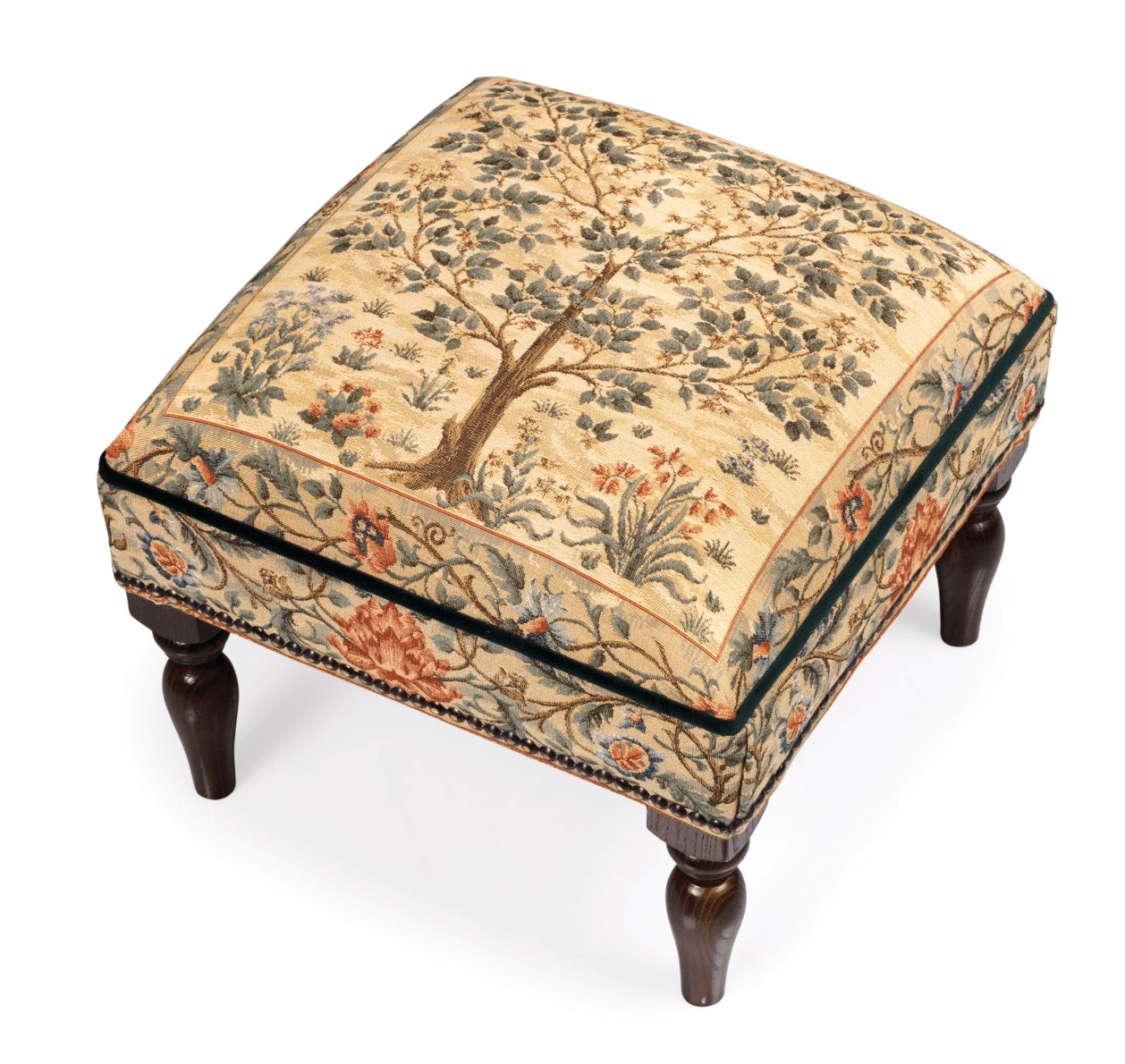 A rectangular ottoman with upholstered top and four carved wooden legs. The upholstered top features a tapestry-like fabric with a central tree motif surrounded by floral and foliate patterns. The sides of the ottoman are also upholstered and adorned with a decorative trim and small decorative studs. The legs are dark stained wood with a turned, tapering shape. — 3D model