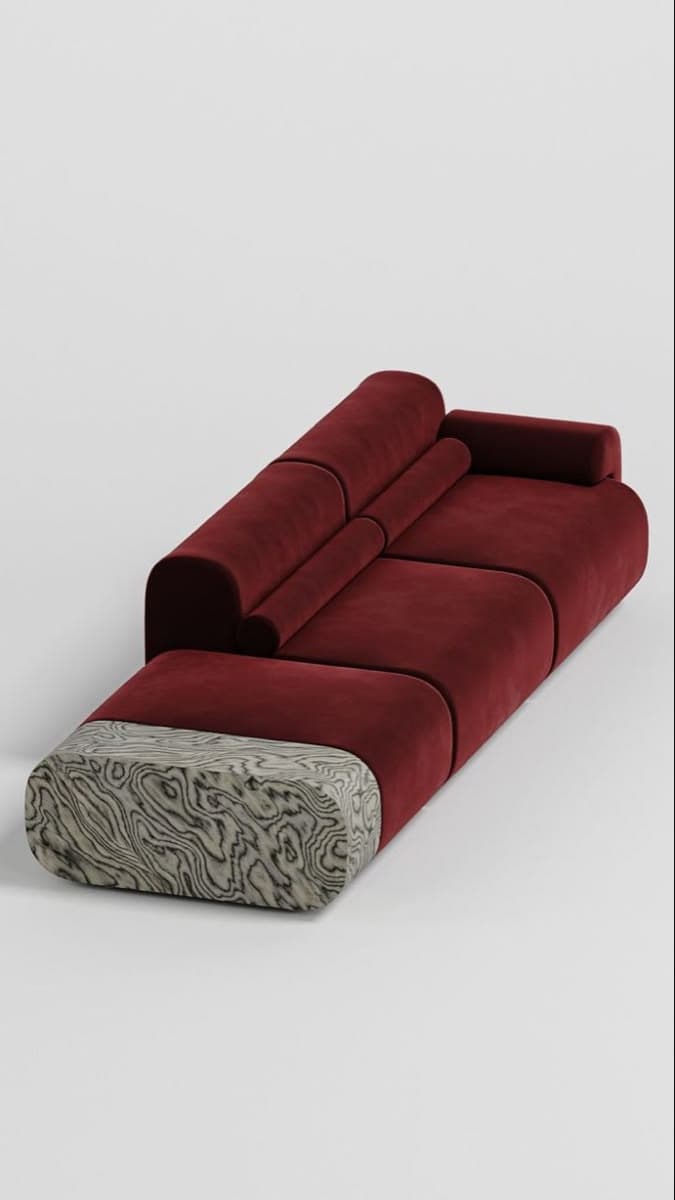 A long, contemporary modular sofa upholstered in deep red velvet, featuring segmented seat and back cushions, and a unique block-like armrest or side element made of highly patterned stone. — 3D model