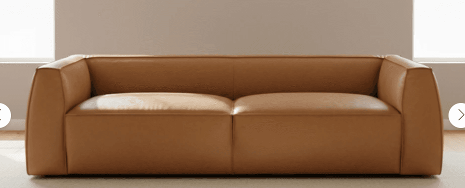 A minimalist, low-profile two-seater sofa upholstered in tan leather, featuring clean lines and integrated, slightly rounded armrests and backrest. — 3D model