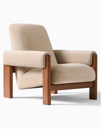 A modern armchair with a wooden frame and upholstered cushions. The armchair features a high backrest, wide armrests, and a supportive seat. The frame is constructed from solid wood, showcasing a natural finish. The upholstery is a soft, neutral-toned fabric, likely velvet or a similar plush material. — 3D model