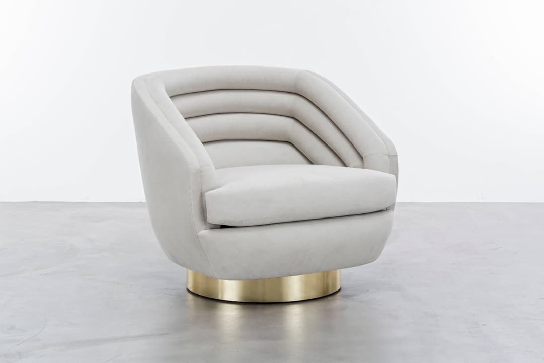 An upholstered lounge chair featuring a barrel-shaped backrest with distinctive horizontal channel tufting, a plush seat cushion, and a circular brass plinth base that allows for 360-degree swivel. — 3D model