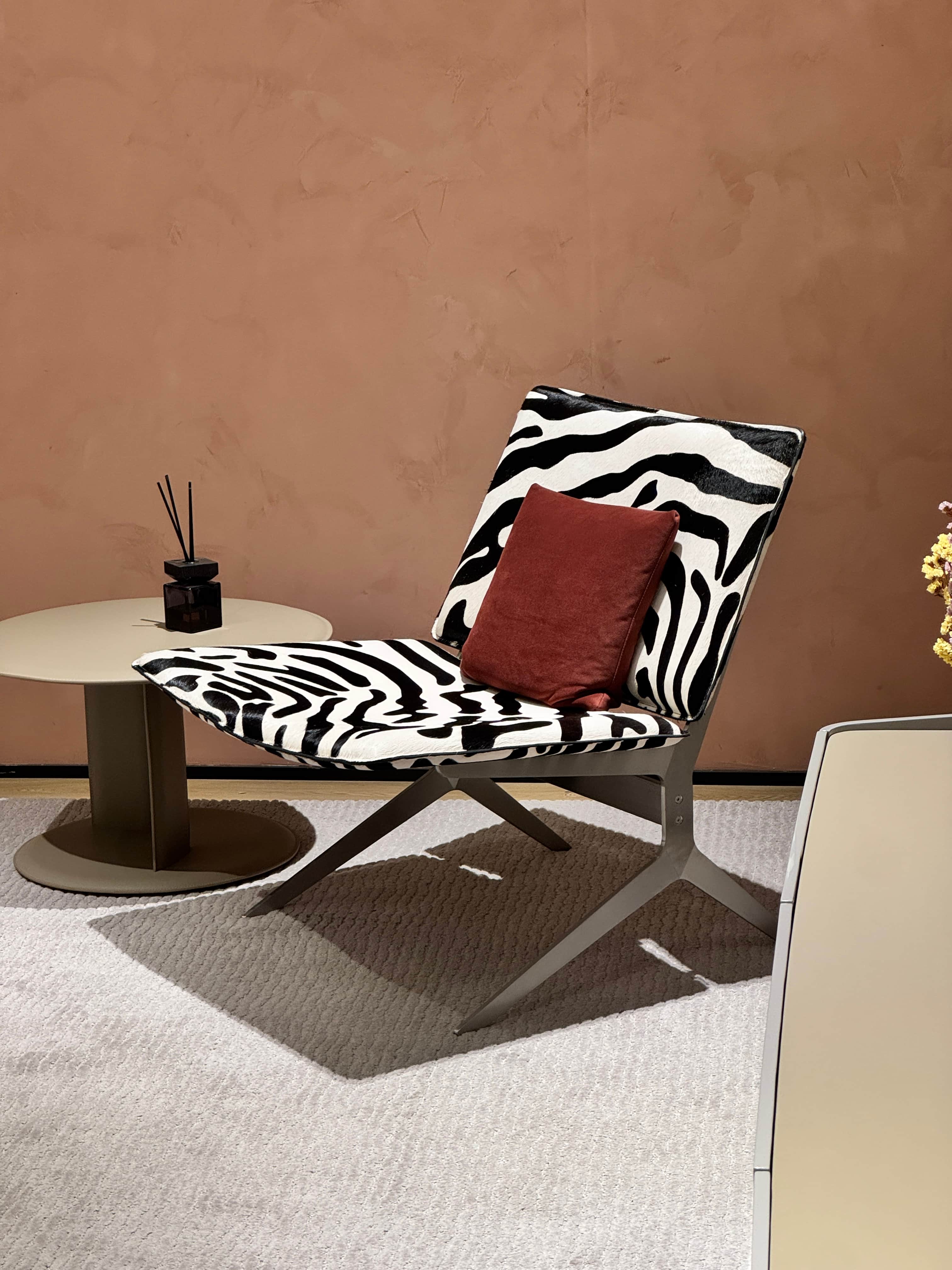 A modern lounge chair with a distinctive zebra print upholstery and a contrasting solid color throw… — free BLEND 3D model