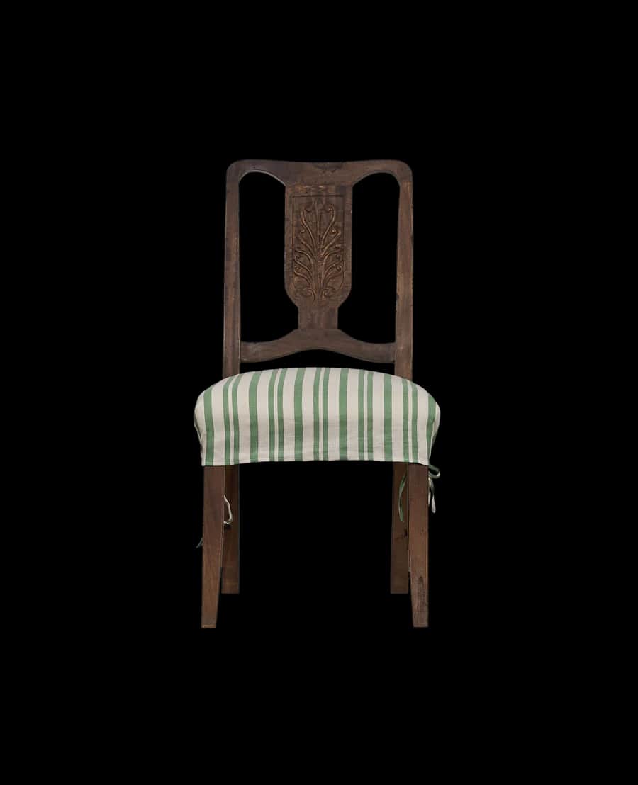 A wooden dining chair with a carved backrest and a striped seat cushion. The chair has a dark wood f… — 3D model